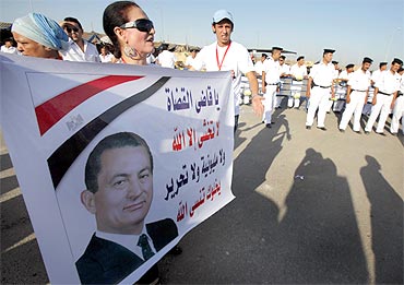 A supporter of former Egypt president Hosni Mubarak holds a poster of him outside the police academy