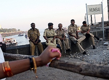 Policemen relax near the Gateway of India in Mumbai