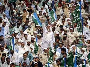 Supporters of Jamaat-e-Islami shout slogans against drone attacks in Karachi