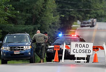 Law enforcement officers set up a road block as investigations continue near the scene of a shooting in Copley, Ohio