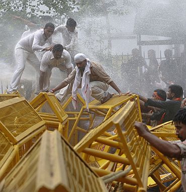 Police spray demonstrators from the India's main opposition Bharatiya Janata Party with water canons as they try to remove barricades during the anti-government march