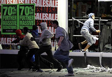 Looters run from a clothing store in Peckham, London on Monday night