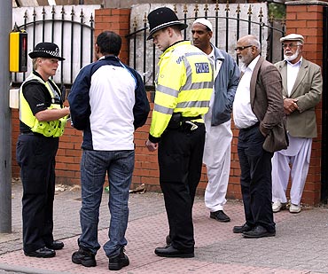 Police officers speak to men at Winson Green area of Birmingham, central England