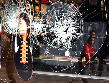 A shoe hangs in the smashed window of the Nike store in Manchester, northern England