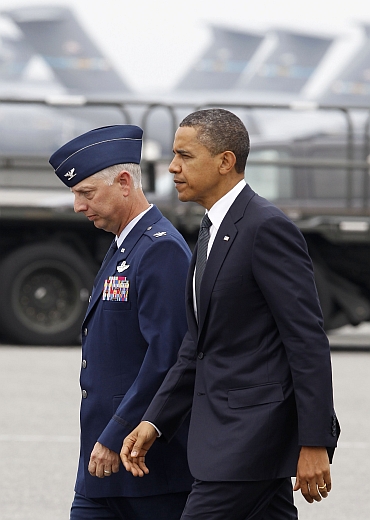 Obama walks with USAF Col Mark Camerer, 436th Airlift Wing Commander, after he arrives at Dover Air Force Base in Delaware