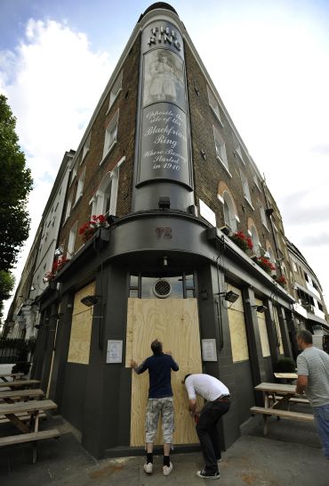 A publican boards up his pub in central London