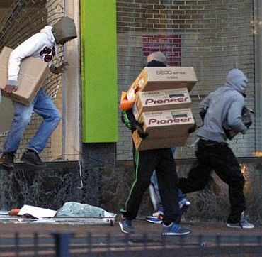 Looters carry boxes of electronic products
