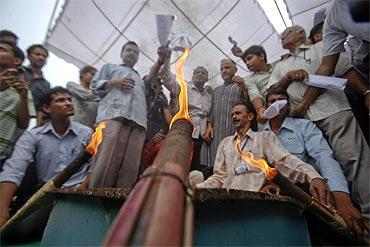 Supporters of activist Anna Hazare burn copies of the Lokpal Bill