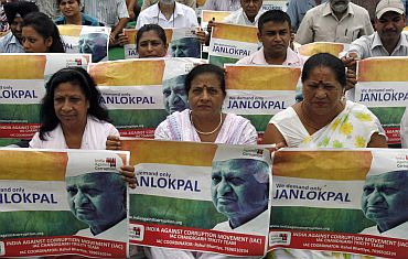 Supporters of Anna Hazare hold his portraits during a rally against corruption in  Chandigarh