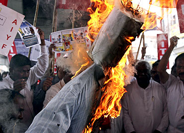 Activists burn an effigy representing the United Progressive Alliance government during a rally in support of Hazare