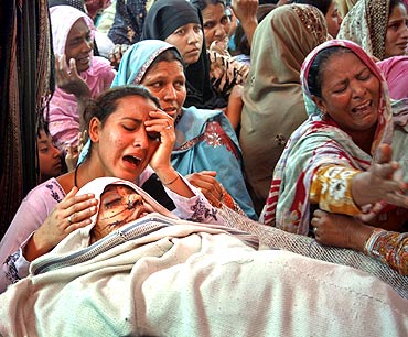 A woman mourns her mother who was killed during suicide bomb attacks in Dera Ghazi Khan