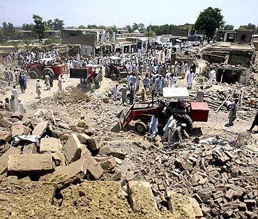 Tractors move rubble from the site of a suicide bomb blast in Pakistan's Pashtun tribal region