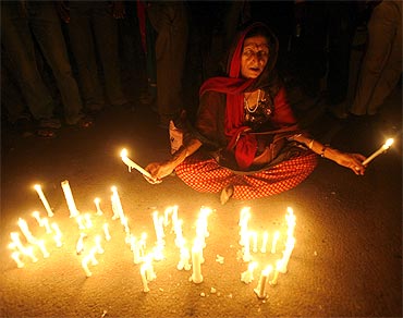 A supporter of Anna Hazare prays during a candlelight protest against corruption in New Delhi