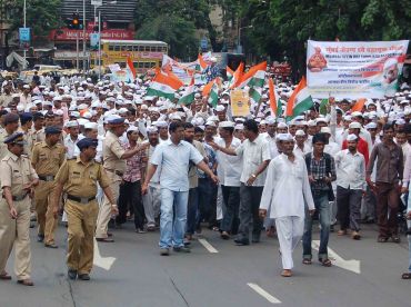 Mumbai's dabbawalas shout slogans as they walk from Churchgate to Azad Maidan in Mumbai in support of Anna Hazare's protest