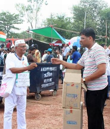An India Against Corruption volunteer distributes biscuits to protestors at Ramlila Maidan
