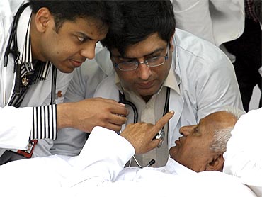 Anna Hazare speaks to doctors as they examine him on the sixth day of his fast at Ramlila grounds in New Delhi