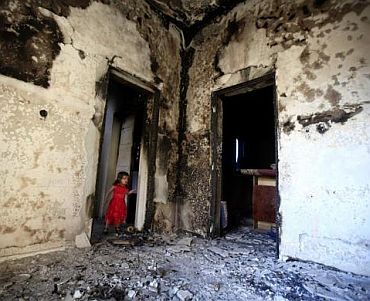 A girl stands in the doorway of a home destroyed in battles between rebel fighters and forces loyal to Muammar Gaddafi on Tripoli street in central Misrata May 29