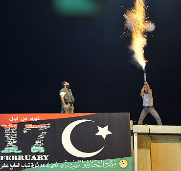 A man lets off fireworks near the courthouse in Benghazi August 22 to celebrate the entry of rebel fighters into Tripoli