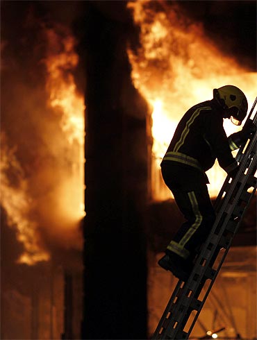 A firefighter climbs a ladder in Tottenham in riot-struck London on August 7