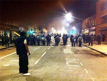 Protestors face off against riot police lines on Tottenham High Road