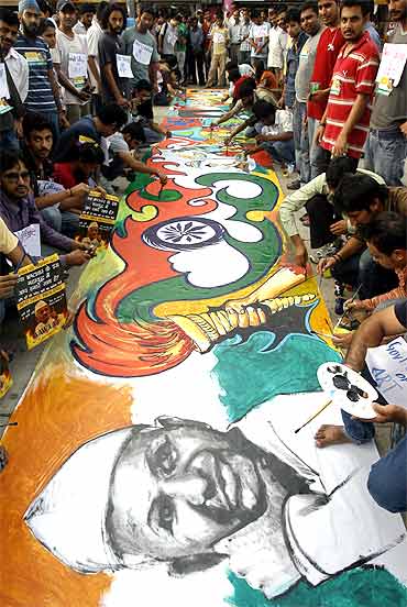 Supporters of Anna Hazare paint a sketch during a protest against corruption