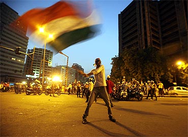 A supporter of Anna Hazare waves India's national flag during a protest march