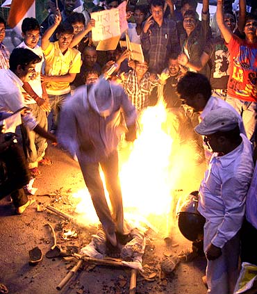 Supporters of Indian social activist Anna Hazare burn an effigy depicting corruption during a protest against corruption in the northern Indian city of Allahabad