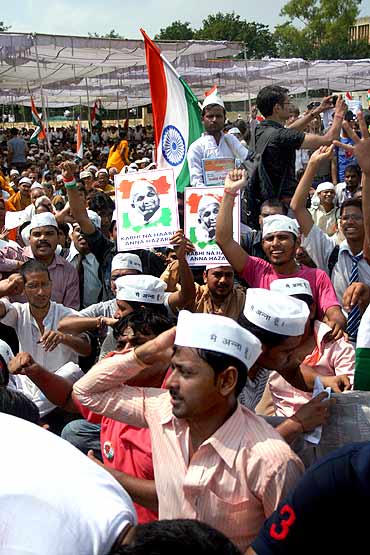 Hazare's supporters shout slogans as they wave Indian national flags at Ramlila grounds in New Delhi