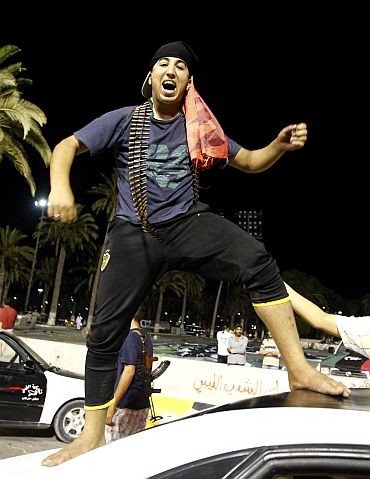 A Libyan rebel fighter celebrates in Green Square, renamed Martyrs Square by rebels, in Tripoli