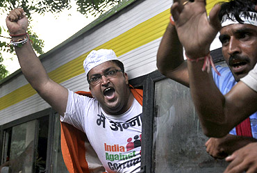 Supporters of Anna Hazare shout slogans from a vehicle after being detained during a protest outside the residence of PM in New Delhi