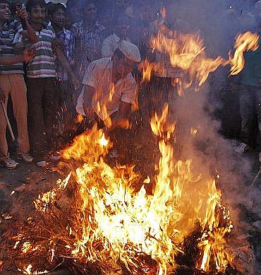 Supporters of Anna Hazare burn an effigy representing corruption during a protest rally in Ahmedabad