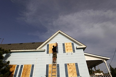 A man boards up the windows of his friend's house at Cape Hatteras National Seashore in Salvo, North Carolina