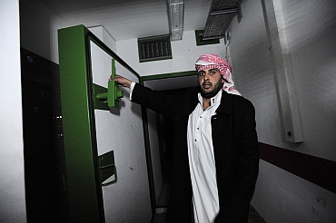 A Libyan man shows a door in the extensive underground tunnels running under Gaddafi's residence