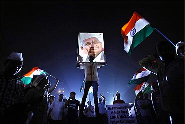 A supporter of Anna Hazare holds his portrait