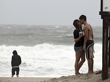 A couple share a kiss as heavy winds and rain move in to the state from Hurricane Irene, on Wrightsville Beach, North Carolina
