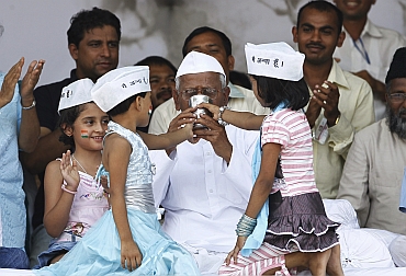 Simran (Left) and Ikra offer coconut water and honey to Anna Hazare