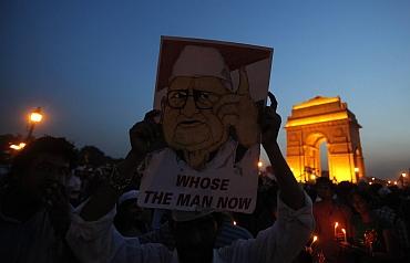 A supporter holds a portrait of Hazare in front of India Gate during the celebrations after the Gandhian ended his fast in New Delhi