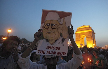 A supporter holds a portrait of Hazare in front of India Gate during the celebrations