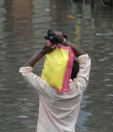 A man makes his way through a flooded street