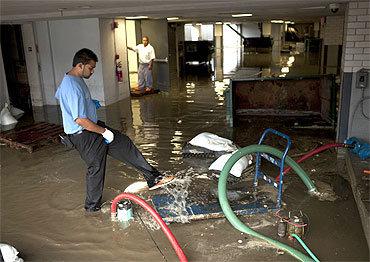 Hotel employees clear water from a flooded area of the Allegria Hotel after flooding from Hurricane Irene in Long Beach, New York