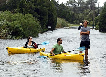 Residents use kayaks to navigate a flooded street in Southampton, New York
