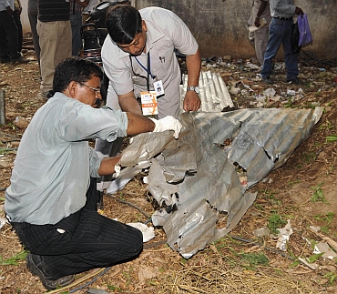 Forensic experts inspect the site of a bomb blast in Bengaluru