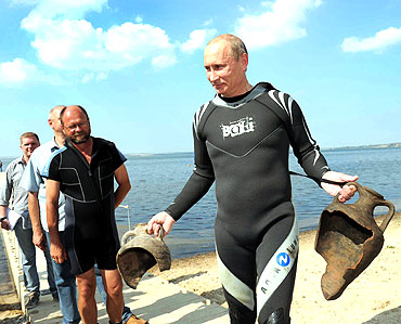Putin carries artifacts he recovered whilst diving at an archaeological site off the Taman peninsular in southern Russia