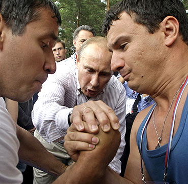 Putin adjudicates an arm-wrestling match during his visit to the summer camp of the pro-Kremlin youth group