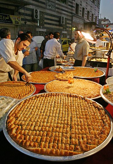 A Syrian seller displays Arabic sweets to sell at an old Damascus market