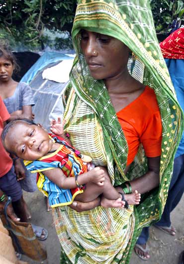 File picture of a woman holding her newborn baby at a flood relief camp in Bihar.