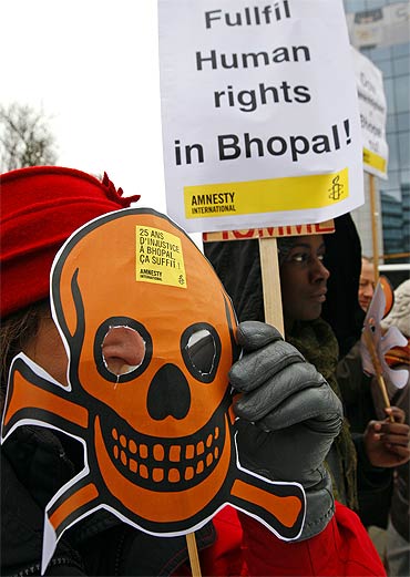 Activists of Amnesty International wear masks representing victims of the Bhopal gas tragedy during a demonstration outside the European headquarters of Dow Chemicals in Brussels