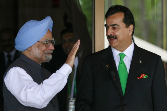 Prime Minister Manmohan Singh waves as his Pakistan's counterpart Yusuf Raza Gilani watches after their joint news conference on the sidelines of the 17th South Asian Association for Regional Cooperation summit, at the Shangri-La in Addu