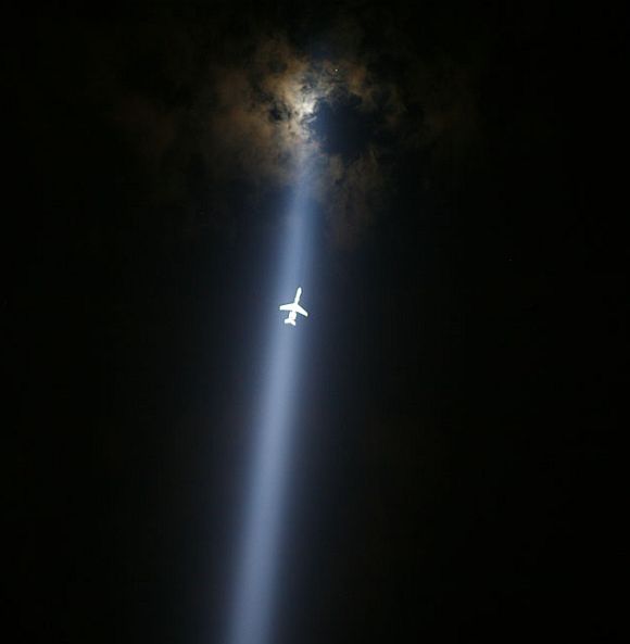 A plane flies through the 'Tribute in Lights' in lower Manhattan in New York September 10, 2011