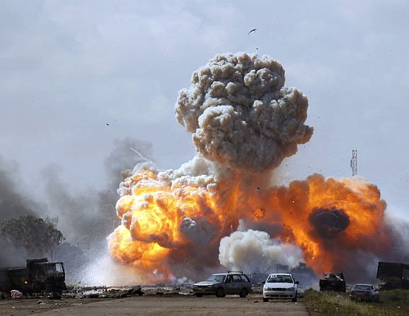 Vehicles belonging to forces loyal to Libyan leader Muammar Gaddafi explode after an air strike by coalition forces, along a road between Benghazi and Ajdabiyah March 20, 2011